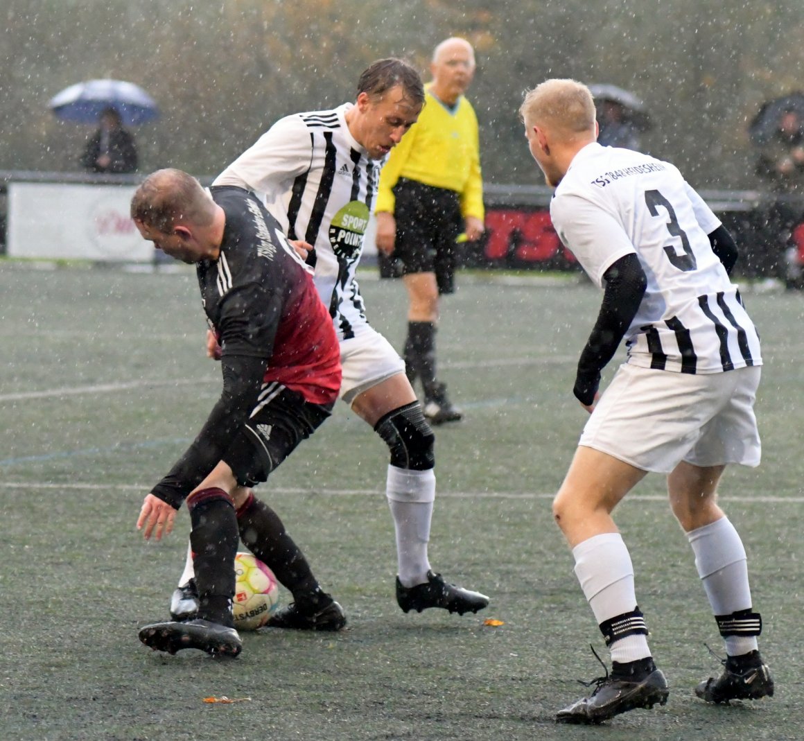 Mittelfeldzweikampf im Dauerregen: Der Stadecker Jerome Haar (l.) und TSG-Kapitän Frederick Netz beharken einander.